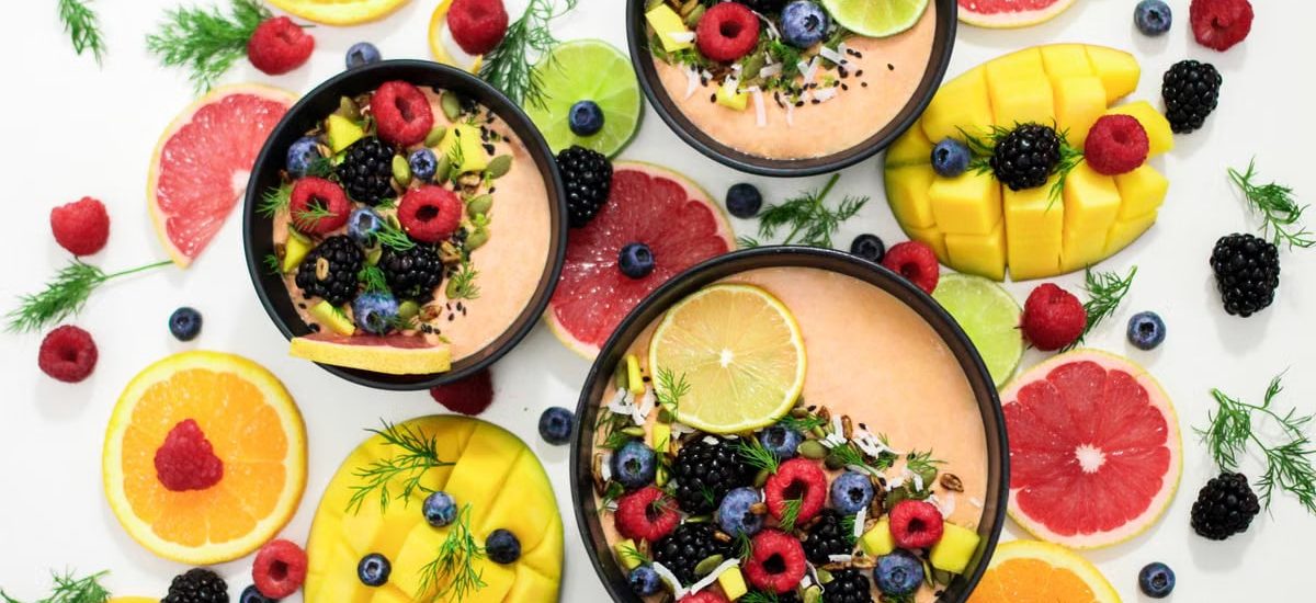 A colorful assortment of fresh fruit bowls featuring mixed berries and citrus slices, perfect for healthy eating inspiration.